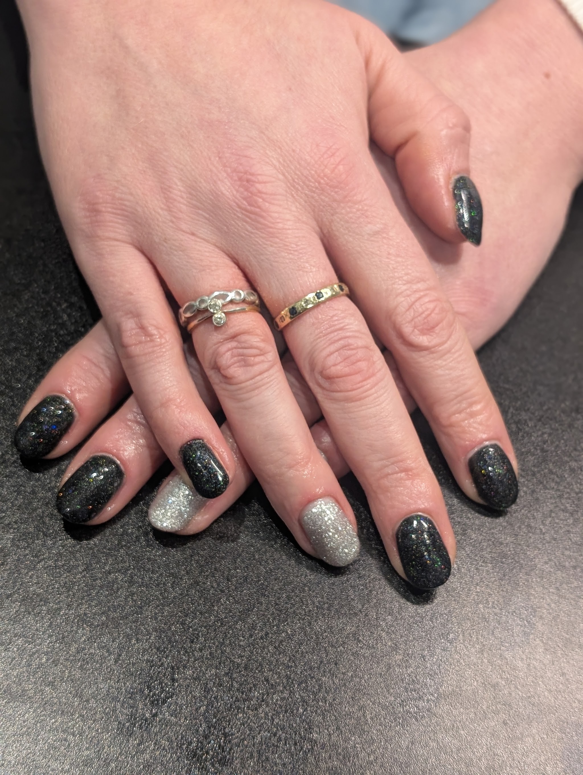 Dark glitter gel nails with one silver sparkle accent nail