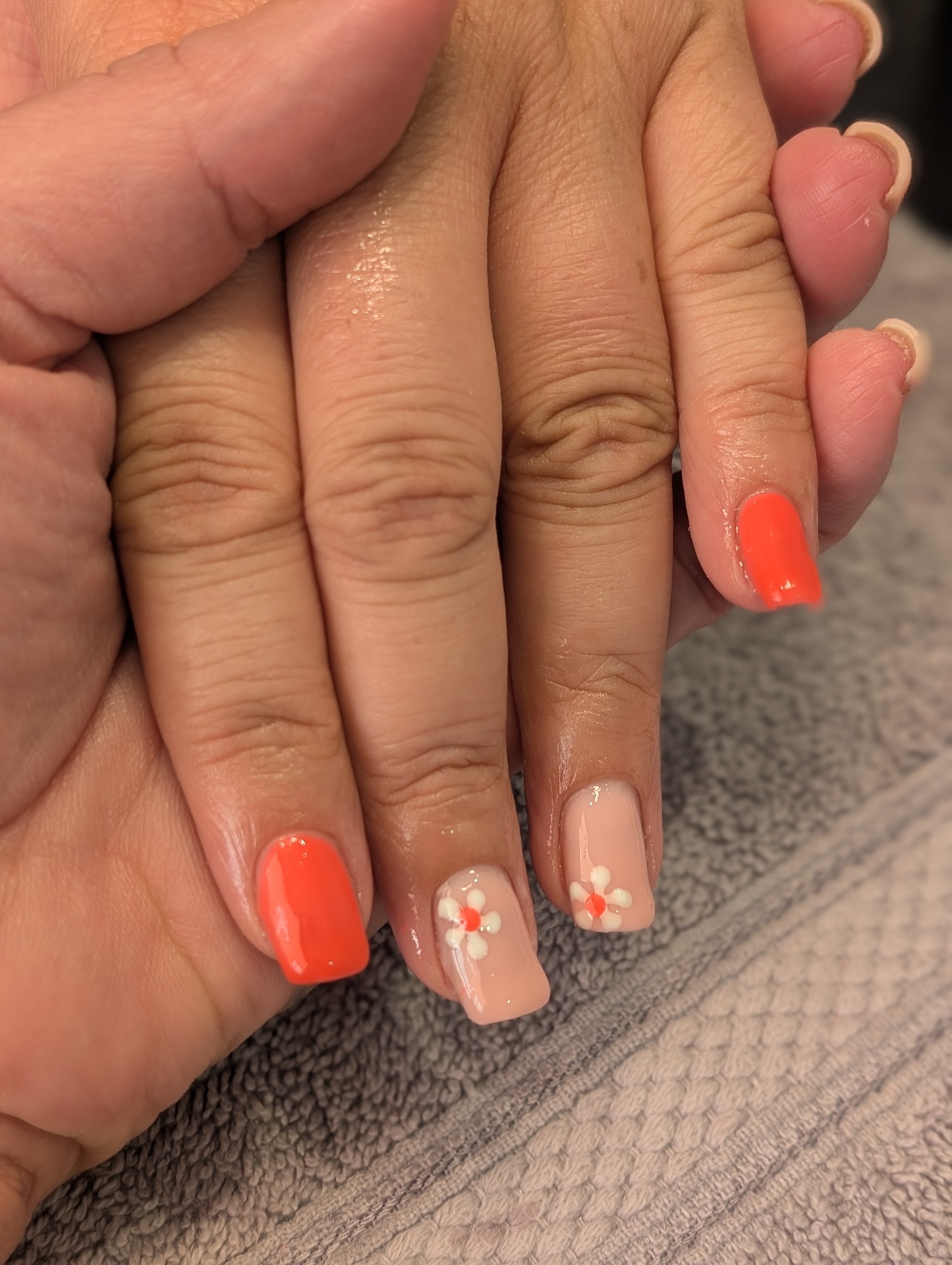 Bright orange and nude gel nails with painted flower nail art