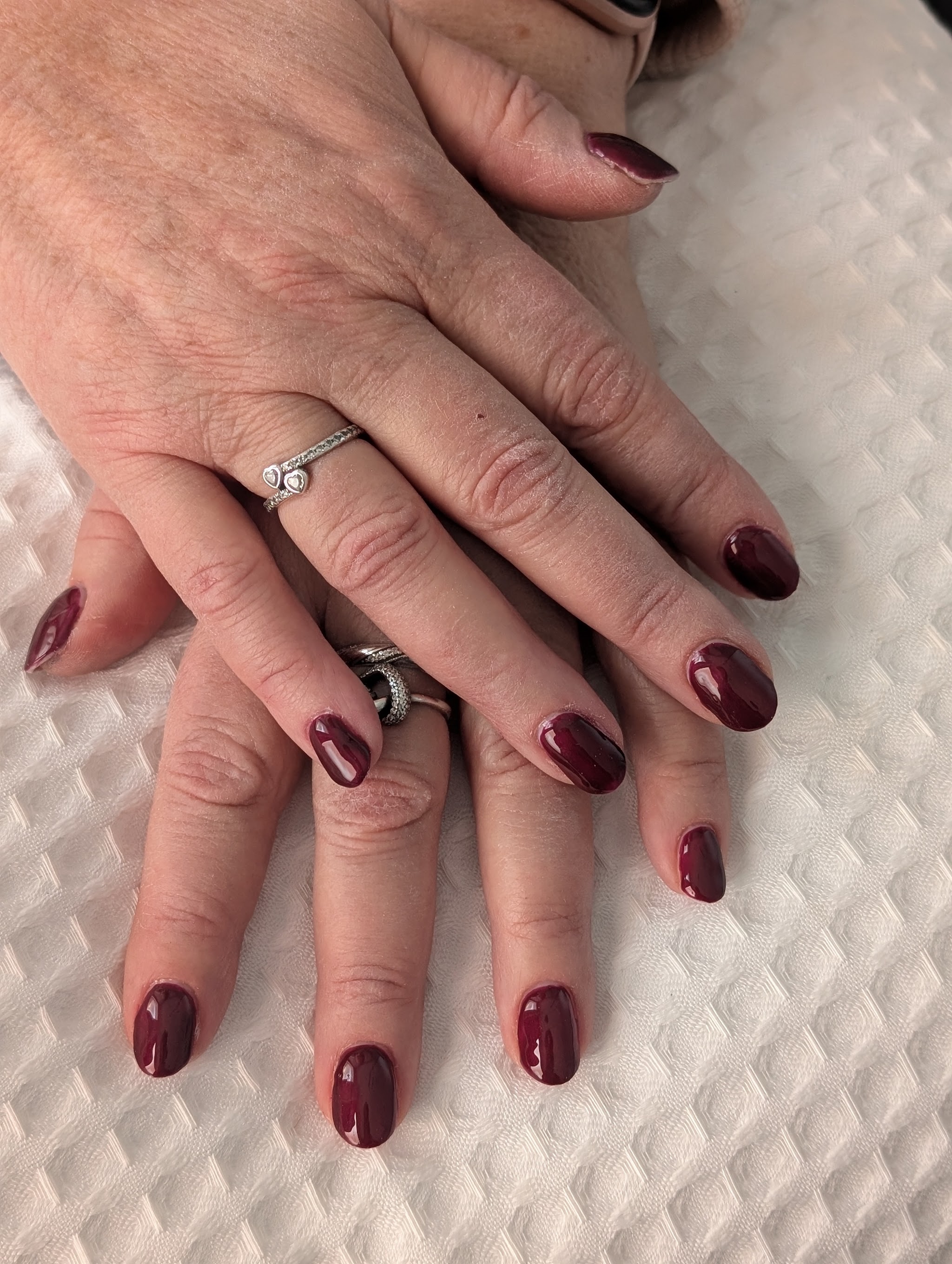 Glossy deep burgundy gel nails on both hands